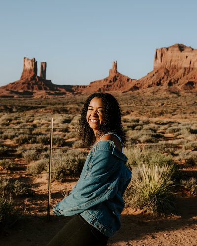 woman smiles in front of rock formations
