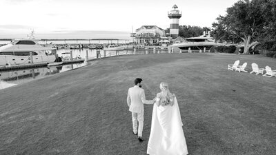 Bride and groom walk along 18th green at the seapines resort