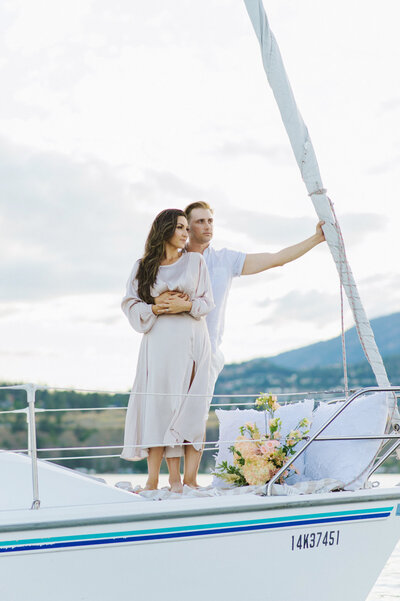 Couple embracing on sailboat, captured by Christy D. Swanberg Photography, editorial elopement and wedding photographer in Calgary, Alberta. Featured on the Bronte Bride Vendor Guide.
