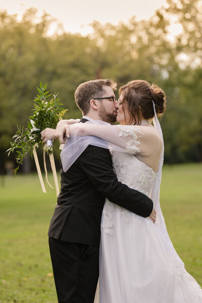 wedding couple kissign both wearing glasses with backlight