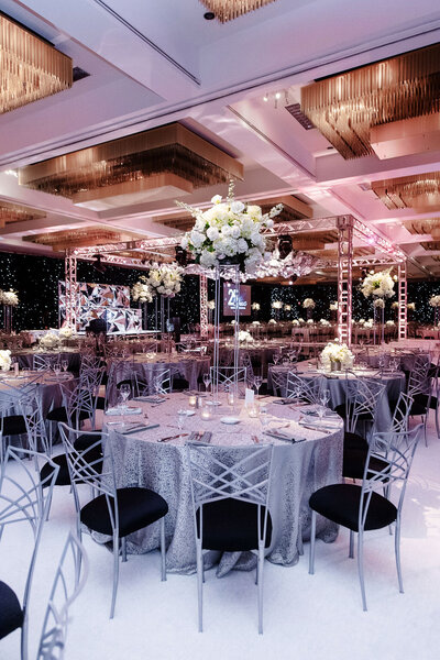 Elegant ballroom reception with tall floral centerpieces.