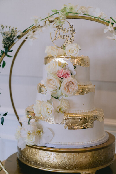 White and gold wedding cake with floral decorations