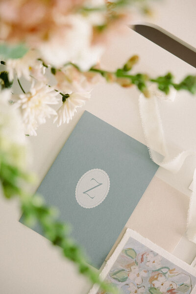 A close up of a notebook with Z for wedding planner Zelie & Co. with florals around it