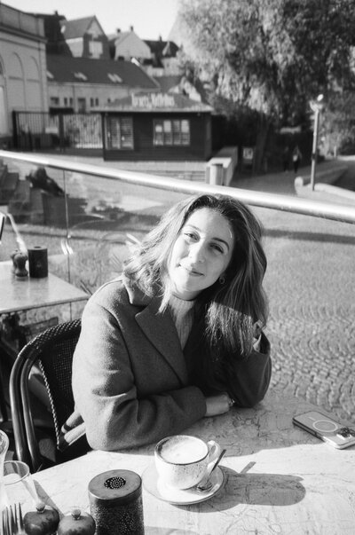 A photo of Clarissa, the owner of Golden Hour Photo Co, in black and white while photographing a destination wedding.