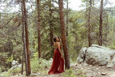 woman with a flower crown and a red dress standing in the forest