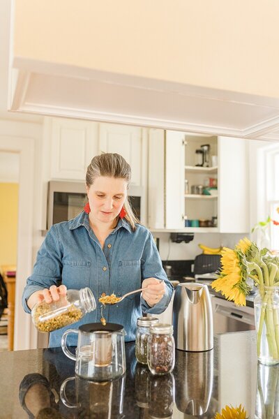 post partum doula makes tea during branding photo session with Sara Sniderman Photography in Natick Massachusetts
