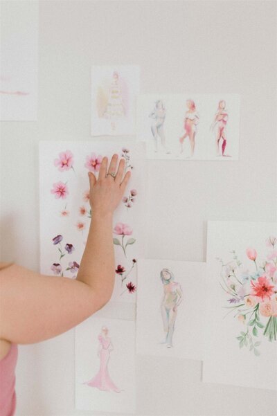 Stephanie Anne Illustration putting artwork up on a wall in a studio in Montreal