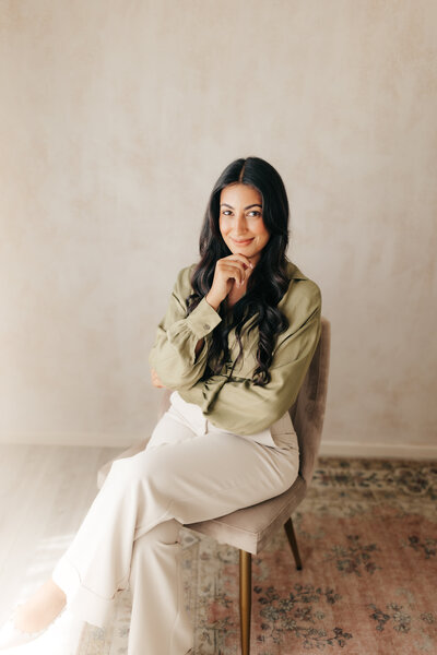 A female business owner sitting in a chair in a Newport Beach studio. 