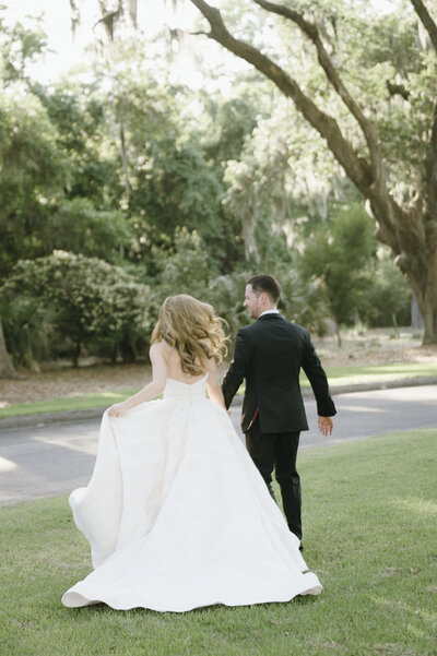 bride and groom running away into sunset