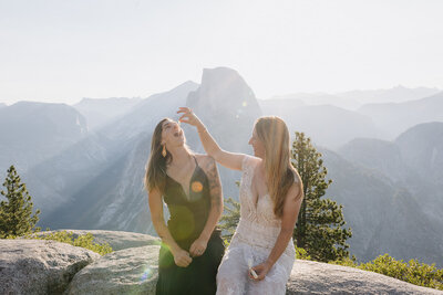 A couple sharing an intimate moment during their Yosemite elopement with the sun rising behind Half Dome.