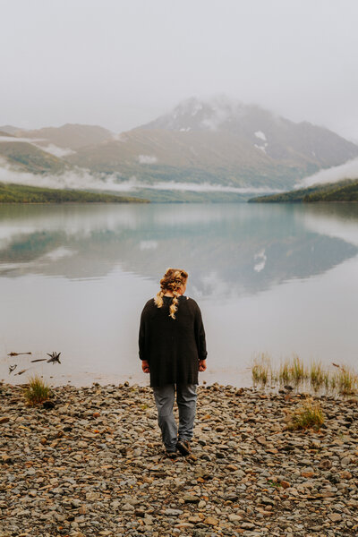 Woman standing facing Lake Eklutna in Alaska