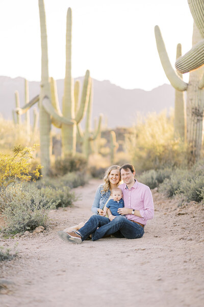 southern california wedding photography of couple cuddling on a manicured path. Bride is wearing designer wedding gown and groom is wearing custom tan suit