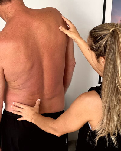 physiotherapist assessing mans back