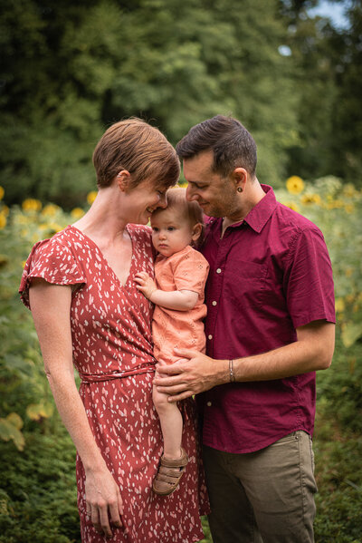 A father holds up his laughing baby girl.