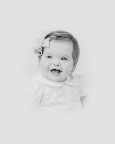 Young girl poses for black and white heirloom portrait in Raleigh NC studio