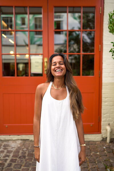 Smiling woman in front of a red door