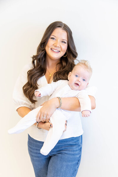 Woman smiling holding her baby in her arms