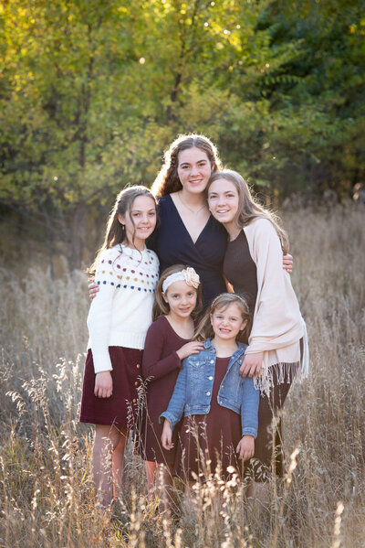 Sisters posing together in a field in Colorado Springs