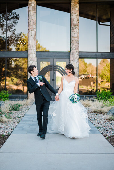 outdoor wedding portraits of bride and groom walking in front of The Oaks with the with denver wedding photographer
