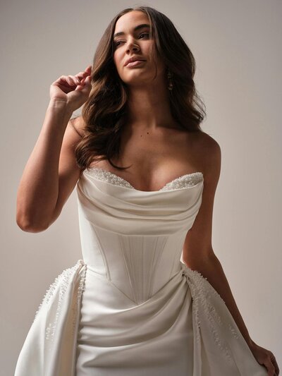 Bride trying on fit-and-flare lace gown Bride trying on fit-and-flare lace gown
