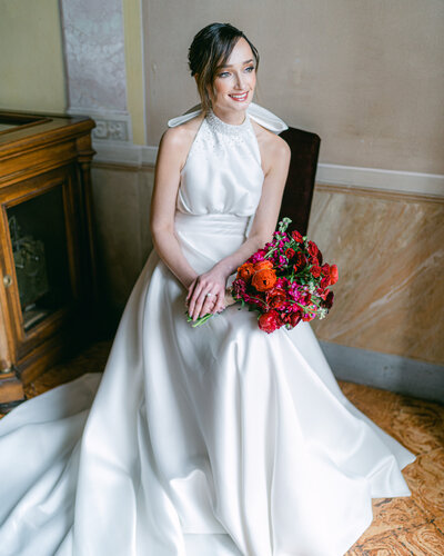 Bride with red bouquet wearing a bespoke bridal gown at Villa Pizzo in Lake Como, Italy
