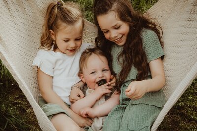 drie kinderen zittend in een kleedje