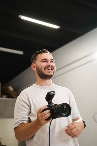 Micah from The Social Impact holding a camera