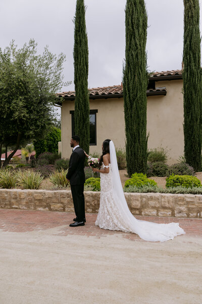 Keiyana touching Chase on the shoulder for their first look, at their wedding in Temecula.