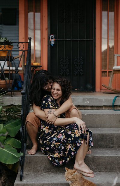 A couple holds one another on the steps.