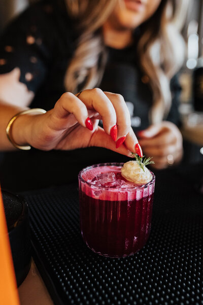 Finishing touches with garnishes for a Byrdie Bar cocktail