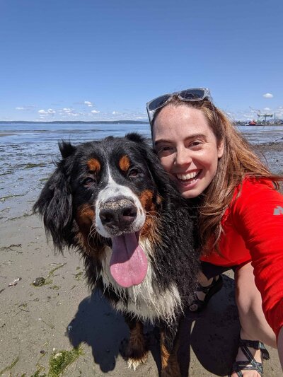 woman and bernese mountain dog smiling at the camera