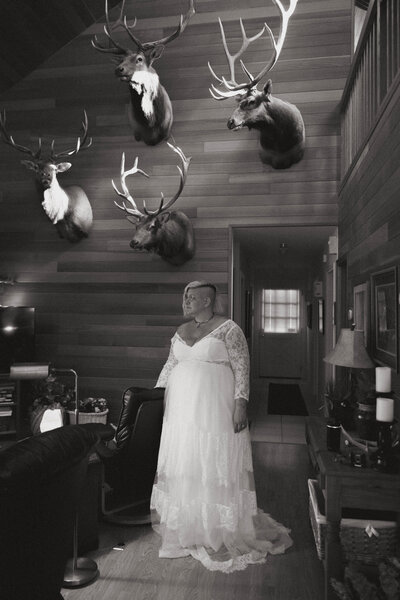 Bride stands in a rustic cabin