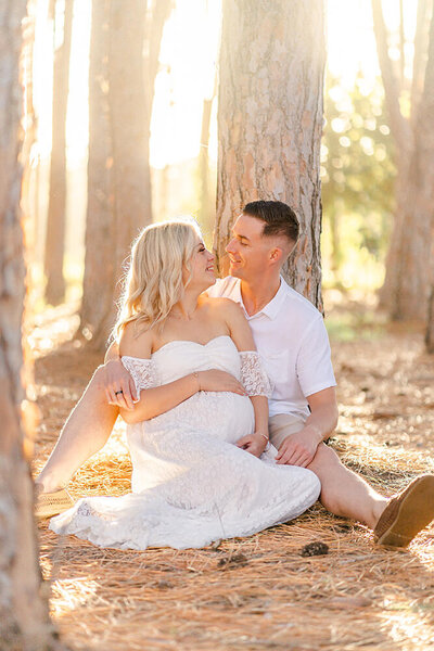 couple sitting in pine forest for maternity photoshoot in Gold Coast QLD