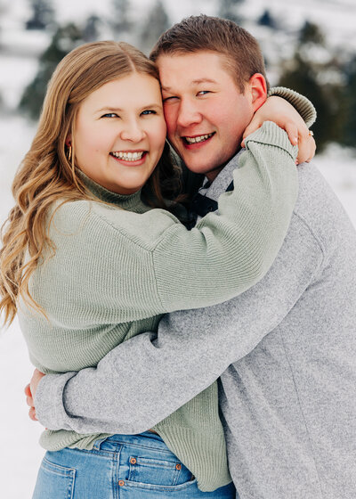Winter engagement photo of Missoula couple embracing in snow