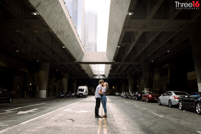 Engaged couple stop in the middle of Lower Grand Avenue in LA to share a kiss