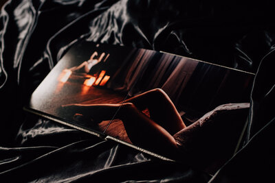 couple looking through woman's boudoir photo album in Ottawa