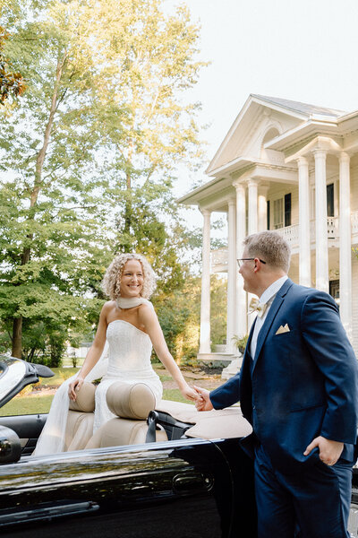 bride and groom holding hands in the car