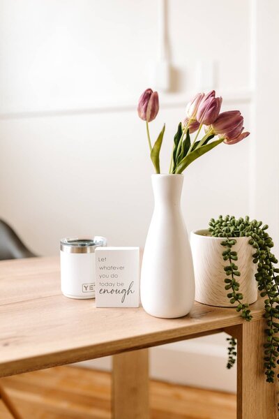 Fresh tulips in a white ceramic vase on McKenna Fahrenbruch’s desk, adding a bright, minimalist touch to the creative workspace at Graceful Exposure Media.