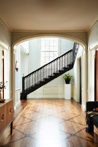 Best Interior Designers in Boston recreate a historic Concord home with a striking black stair in the formal foyer, as featured in Boston Magazine.