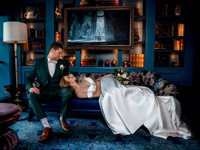 couple laying down in a beautiful fairytale looking room in wedding outfits at disney