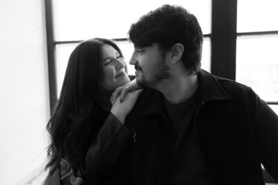 Couple posing together in a natural light studio with a minimal backdrop in Fall River MA
