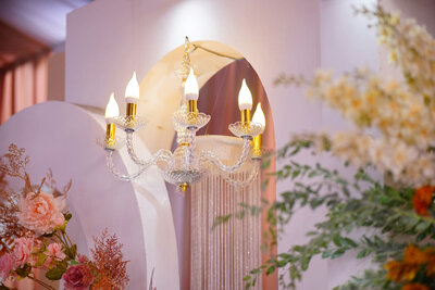 An elegant chandelier with a wall design with pink flowers