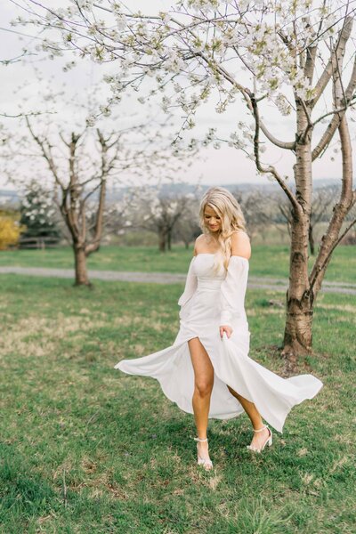 bride dancing under flower tree in her wedding dress in northern a va vineyard
