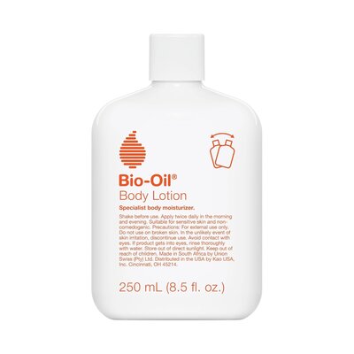 White bottle of Bio-Oil Body Lotion with orange logo on a neutral background, used for dry skin and stretch marks. 