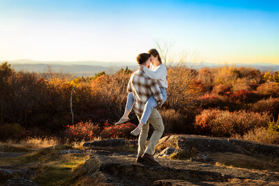 Happy baby smiling while mom kiss the side of her head during fall engagement session at the Audubon in Auburn NH