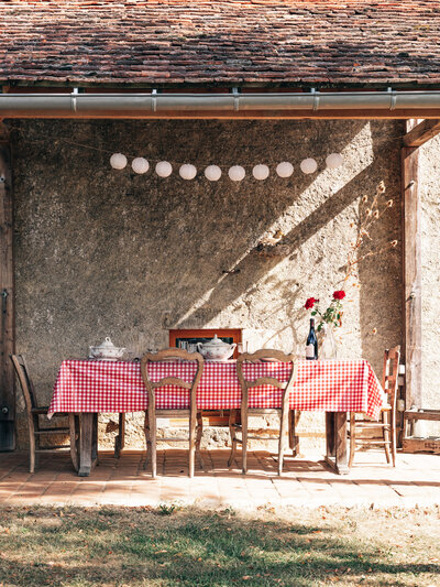 Charmante buitenruimte van een vakantiewoning, ideaal voor gasten om in een rustieke setting te genieten van een sfeervol diner. Een prachtige toevoeging voor verhuurplatformen zoals Airbnb en Booking.com.
