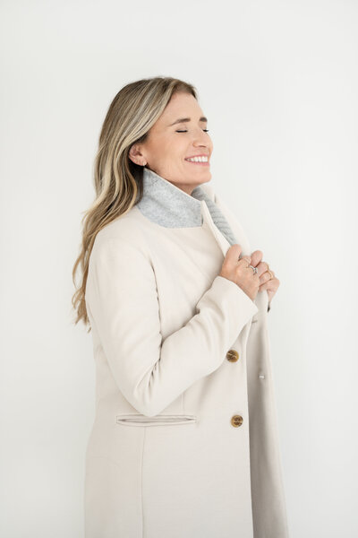 Corporate coach Wendy Tamis Robbins wearing a tan coat and smiling