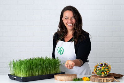 Ottawa branding photography showing a farmer in her white apron at her workstation of grass and seeds.  Captured in studio by JEMMAN Photography COMMERCIAL