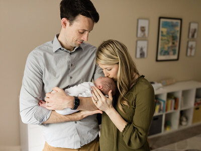 parents holding newborn baby boy for in home lifestyle session