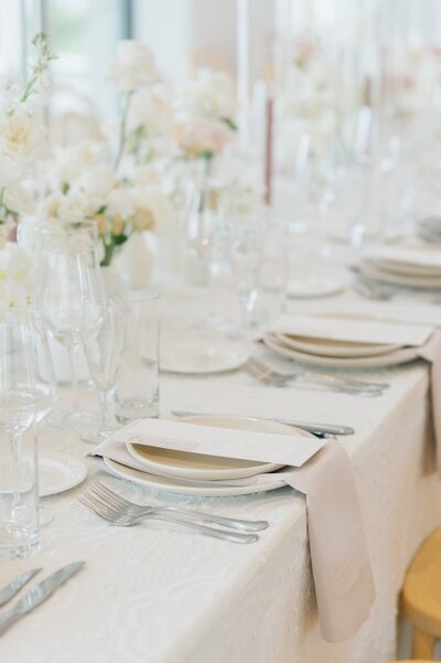 white table setting  with soft pink neutral napkins and candles designed by Sipilla Soirees, wedding planners in Columbus Ohio